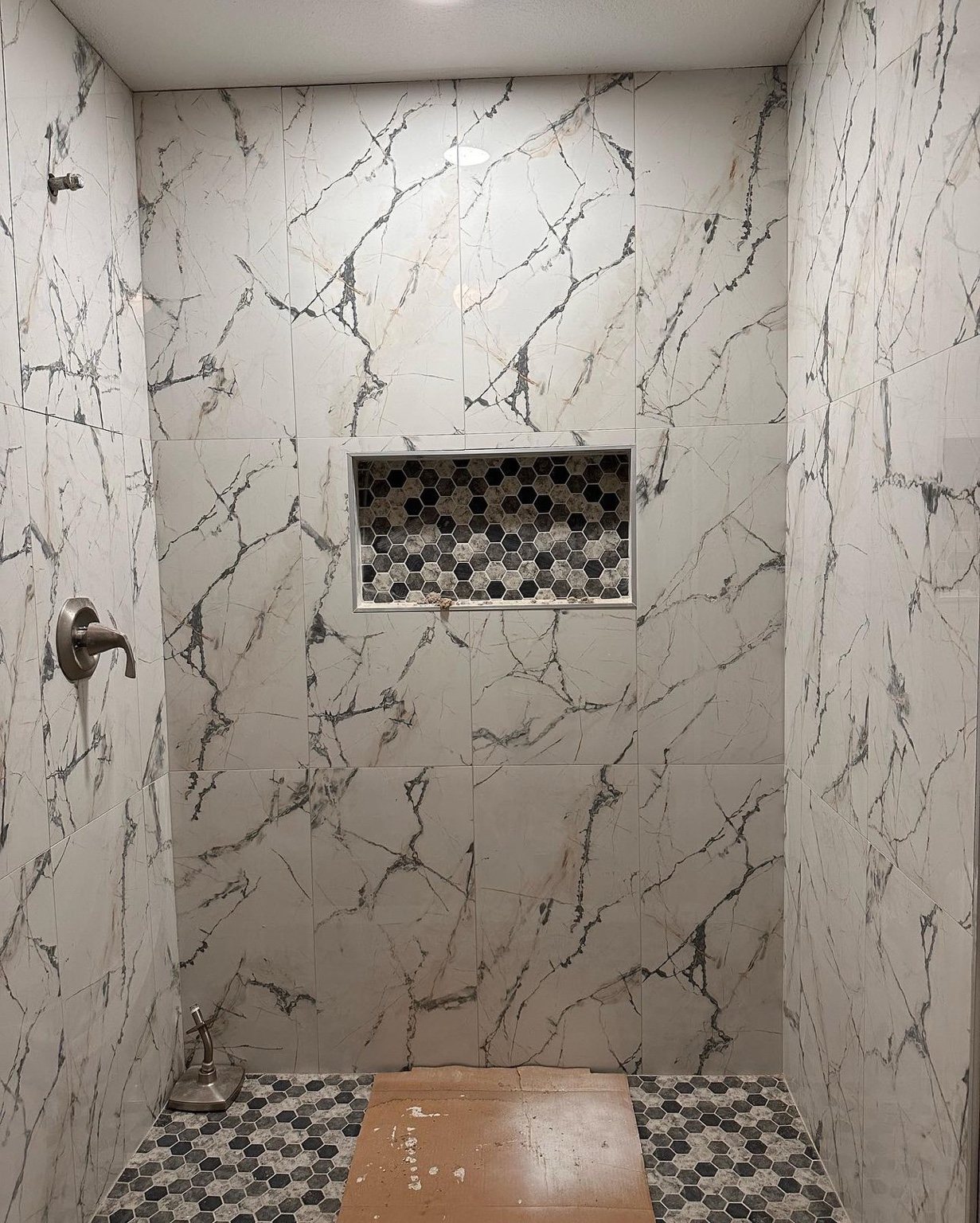 Large-format shower tile installation in progress